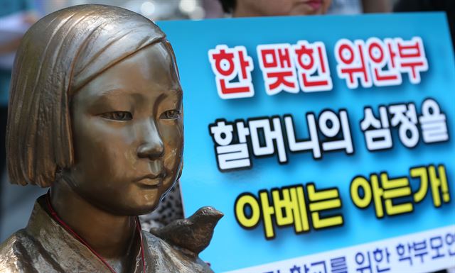 11일 오후 서울 종로구 일본대사관 앞에서 열린 '고노담화 부정하는 일본 아베정부 규탄 기자회견'에서 피해 할머니 심정이 적힌 피켓이 소녀상 옆에 서 있다. 한국일보 자료사진