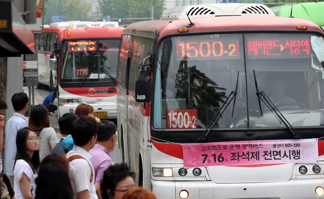 경기도와 서울 간 고속화도로를 지나는 직행좌석형(빨간색) 광역버스의 입석 운행이 금지된 16일 오전 서울 지하철 2·4호선 환승역인 사당역 인근 한 광역버스 정류장에서 승객들이 버스를 타기 위해 줄지어 서 있다. 연합뉴스