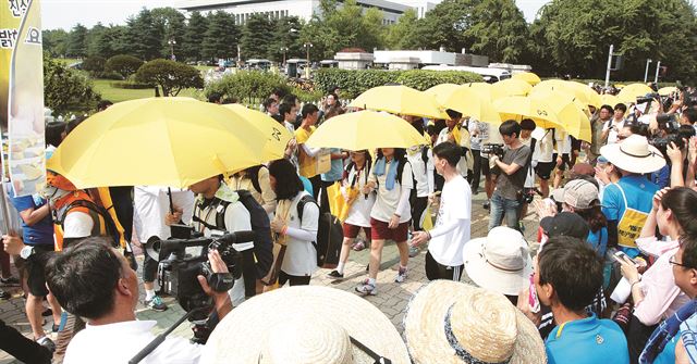 안산 단원고 2학년 세월호 침몰 사고 생존 학생들이 노란 우산을 쓰고 16일 오후 1박 2일 도보 행진 목적지인 서울 여의도 국회 앞에 도착하고 있다. 오대근기자 inliner@hk.co.kr