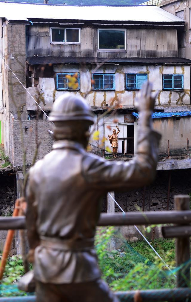 건물 뒷편에 도시락을 들고 출근하는 광부와 아이를 업고 배웅하는 아내의 동상이 세워져있다.