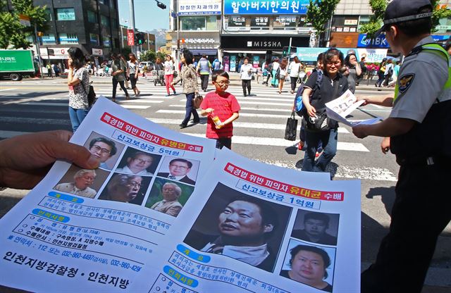 '세월호 실소유주 비리'를 수사 중인 인천지검 특별수사팀(팀장 김회종 2차장검사)은 17일 유병언(73) 전 세모그룹 회장(청해진해운 회장) 일가의 실소유 재산 344억원 상당에 대해 기소 전 추징보전 명령을 법원에 청구했다. 사진은 유병언 전 세모그룹 회장(청해진해운 회장)과 장남 대균씨의 수배전단지를 시민들에게 나눠주고 있는 모습. 한국일보 자료사진