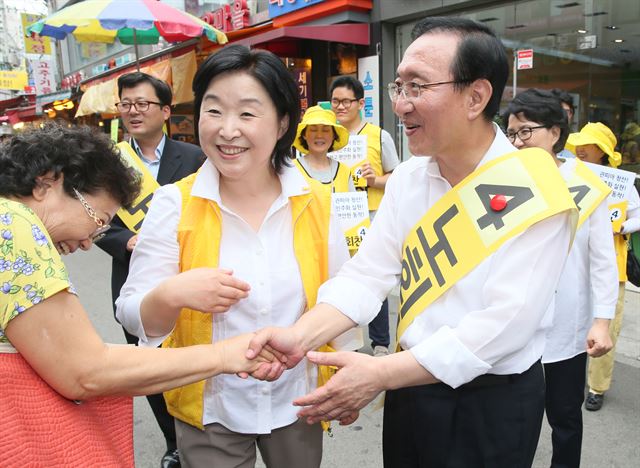 7·30 재보궐선거 서울 동작을 국회의원에 출마한 정의당 노회찬 후보(오른쪽)가 17일 서울 동작구 남성시장 내에서 심상정 원내대표(가운데) 등과 함께 주민들에게 인사하고 있다. 연합뉴스