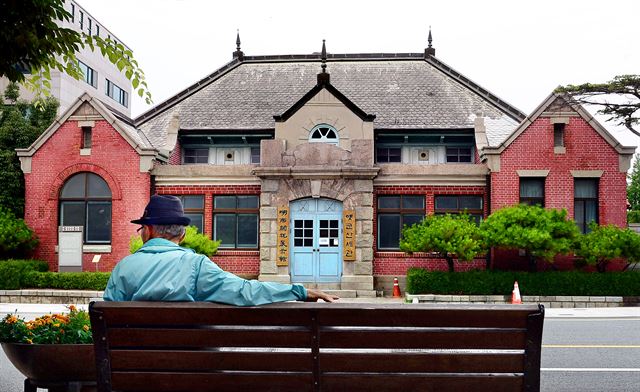 군산근대역사박물관 옆 해망로에는 세관과 은행 등 일본 제국주의 수탈의 상징이었던 기관들이 몰려 있었다. 옛 군산세관 건물 앞에서 한 시민이 휴식하고 있다.