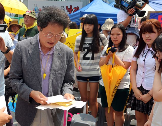 조희연 서울시교육감이 27일 서울 용산 화상경마장 운영 반대 농성장을 찾아 시위를 벌이던 주민이 건넨 편지를 읽고 있다. 연합뉴스