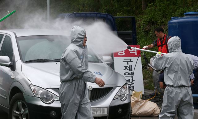 24일 오전 구제역이 발생한 경북 의성군 비안면 한 돼지농가 주변에서 방역당국이 차량 통행을 제한하고 긴급 방역 작업을 하고 있다. 연합뉴스