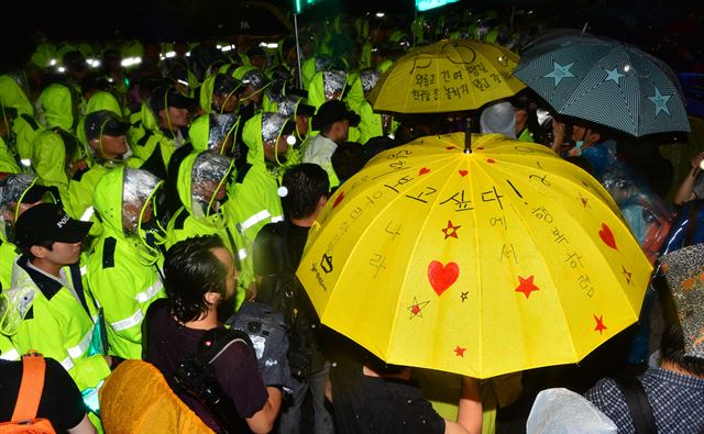 24일 서울광장에서 열린 세월호 추모문화제를 마치고 행진하던 유가족과 시민단체 회원들이 25일 새벽 광화문광장에서 경찰과 대치하고 있다. 뉴시스