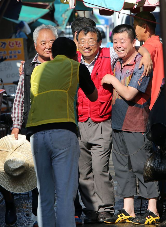 7·30 재보궐선거에서 대이변을 일으키며 전남 순천·곡성에서 당선된 새누리당 이정현 당선인이 31일 오전 순천시 역전시장을 자전거로 돌며 상인들과 인사를 하다 기념촬영을 하고 있다. 연합뉴스