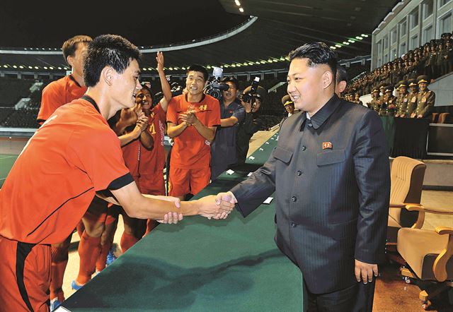 김정은 북한 국방위원회 제1위원장이 지난해 8월 28일 평양 김일성경기장에서 횃불컵 1급 남자축구 결승전을 관람한 후 선수들과 악수하고 있다. ●평양=조선중앙통신