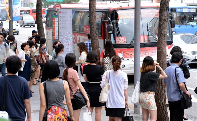 경기도와 서울 간 고속화도로를 지나는 직행좌석형 광역버스의 입석 운행금지 둘째날인 지난 7월 17일 오후 서울 명동 부근 버스정류장에 시민들이 버스를 타기 위해 줄 서 있다. 홍인기기자 hongik@hk.co.kr