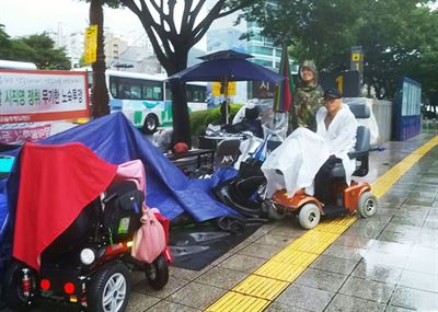 지난 3일 오전 폭풍우속에서 밤을 지새운 4.20실천단 장애인들이 처참한 모습으로 노숙 농성을 이어나가고 있다. 4.20실천단 제공