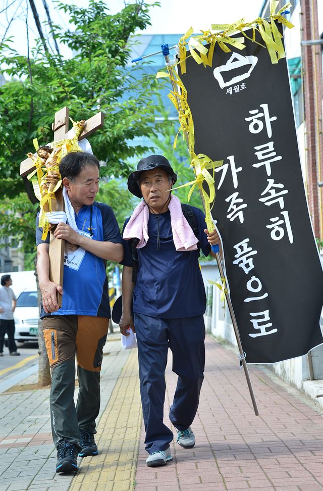 8일 오후 경기 안산 단원고 앞에서 세월호 희생자 학부모들이 십자가를 메고 진도 팽목항과 프란치스코 교황이 방한해 미사를 갖는 대전월드컵경기장까지 800Km, 1900리 길을 도보로 행진하는 대장정에 나서고 있다. 도보행진에 나선 희생자 학부모들은 세월호 참사를 잊지 않고 11명의 실종자 무사귀환 기원, 철저한 진상규명과 특별법 제정 촉구 등을 위해 마련했다고 밝혔다. 뉴시스