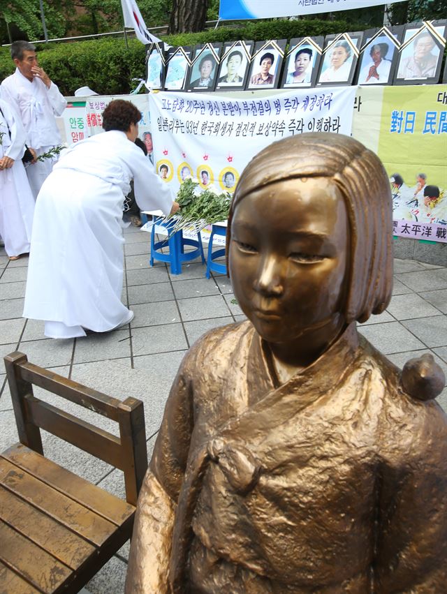 4일 오전 서울 종로구 일본대사관 앞에서 열린 '고노담화 탄생 21주년 증언청취 일본군대 위안부 16명 중 사망 14명 추도식'에서 태평양전쟁희생자유족회 회원들이 헌화하고 있다. 연합뉴스