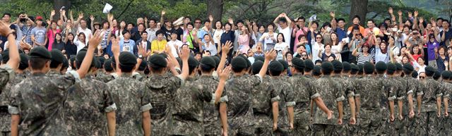 충남 논산시 연무대 육군훈련소에서 5주간의 훈련을 마친 훈련병들이 6일 수료식에서 면회온 가족들에게 손을 흔들고 있다. 논산=왕태석기자 kingwang@hk.co.kr