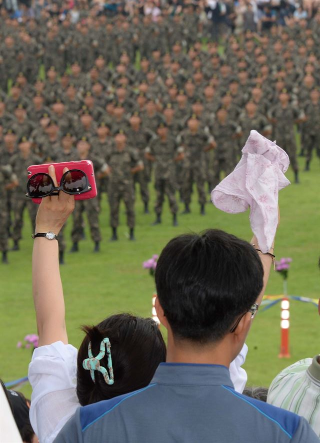 충남 논산시 연무대 육군훈련소에서 5주간의 훈련을 마친 훈련병들이 6일 수료식을 하는 가운데 재회를 기다리는 부모들이 손을 흔들고 있다. 논산=왕태석기자 kingwang@hk.co.kr