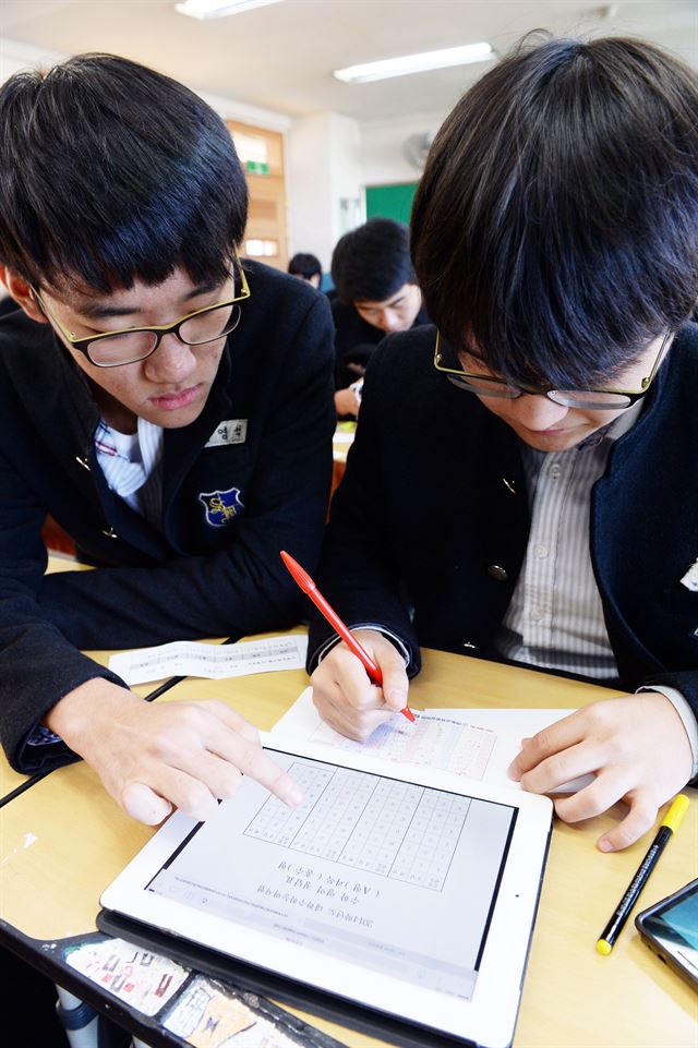 학생들이 수험표 뒤에 적오 온 답을 태블릿 PC를 이용해 맞춰보고 있는 모습. 한국일보 자료사진