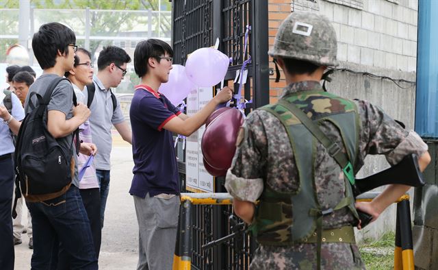 5일 오전 경기도 동두천시 육군 28사단 보통군사법원에서 윤 일병 사망 사건 시민 감시단이 군 문화 개선을 촉구하며 메모와 풍선을 붙이고 있다. 연합뉴스