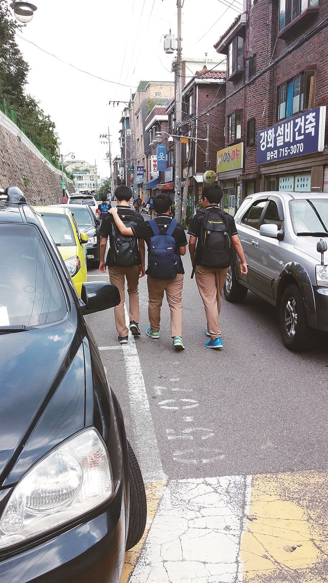 서울 환일고 학생들이 8일 오후 차량이 빽빽하게 늘어선 중구 만리동 환일길을 지나고 있다. 장재진기자 blanc@hk.co.kr