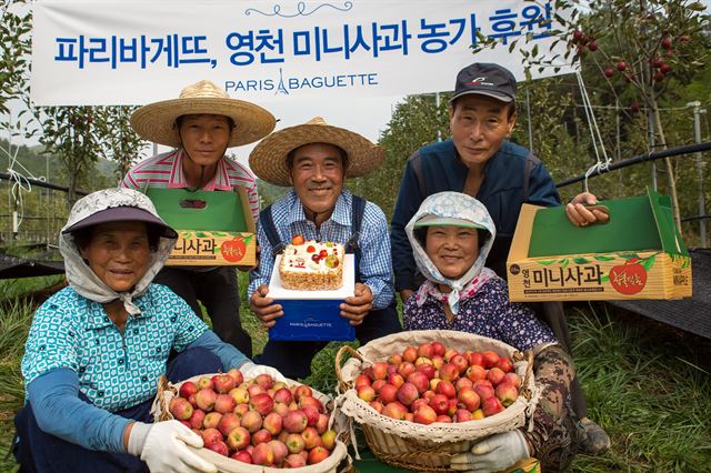 경북 영천에서 미니사과(알프스오토메 품종) 재배하는 최병혁씨와 농부들이 재배한 미니사과를 안고 활짝 웃고 있다. SPC 제공