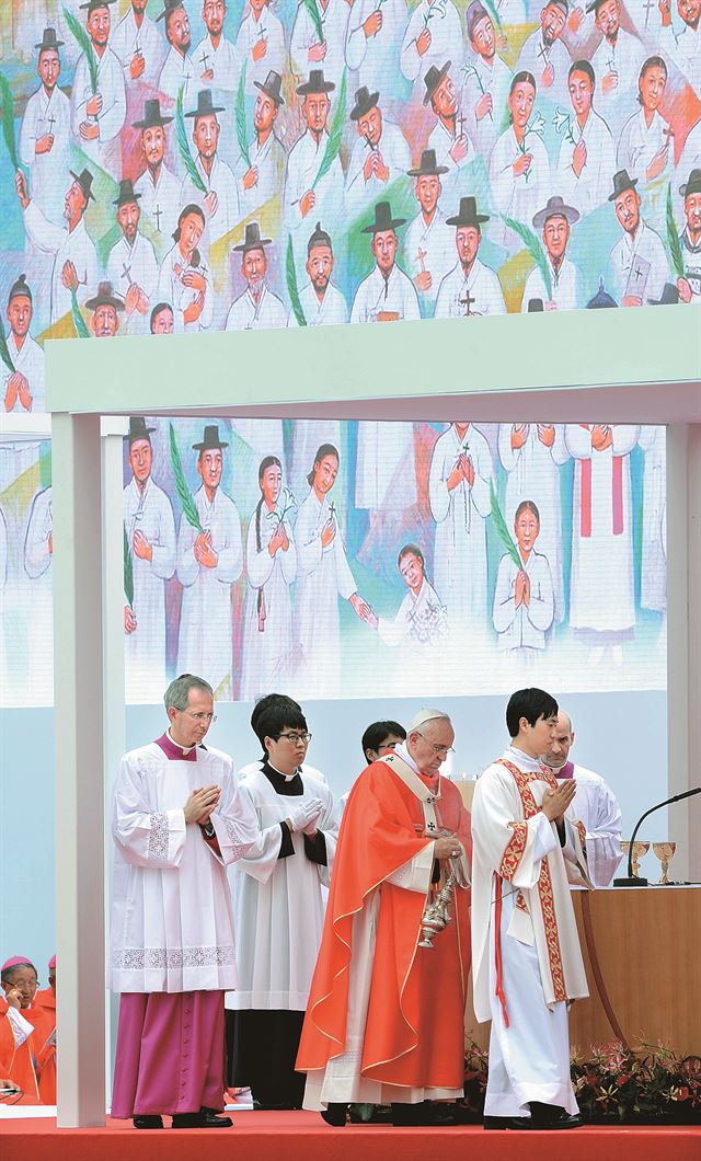 프란치스코 교황이 16일 한국 순교자 124위를 복자로 선포하는 순간 이들을 그린 대형 걸개그림이 공개됐다. 김영주 화백이 그린 이 그림에는 '새벽 빛을 여는 사람들'이라는 제목이 붙었다. 그림 속 복자들이 죽음에서 생명으로 건너가 하는님 나라에서 기뻐하고 있다. 사진공동취재단