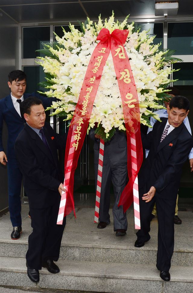 고 김대중 전 대통령의 서거 5주기를 하루 앞둔 17일 개성공단 종합지원센터 옆 북측 개성공단 총국사무소에서 북측 관계자들이 김정은 국방위원회 제1위원장 명의의 조화를 우리측 차량으로 옮기고 있다. 연합뉴스