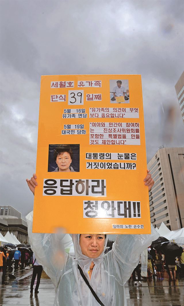 세월호 참사 유족 김영오씨가 39일째 단식농성을 하고 있는 21일 서울 광화문광장 앞에서 한 시민이 유가족 의견을 존중한 세월호 특별법을 촉구하는 피켓 시위를 하고 있다. 김주성기자 poem@hk.co.kr