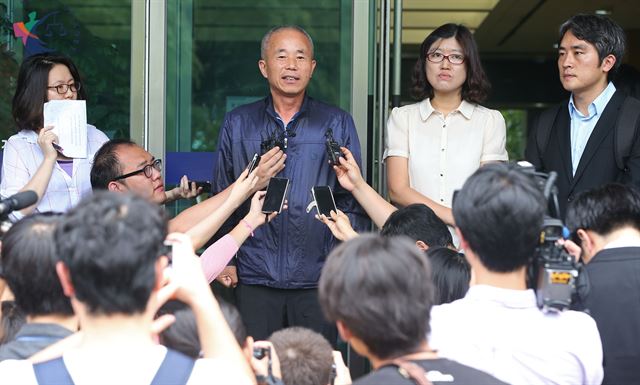 삼성전자 반도체공장에서 일하다 백혈병으로 숨진 고 황유미씨의 아버지 황상기(왼쪽에서 두번째)씨가 21일 서울 서초동 서울고등법원 별관 앞에서 항소심에서도 산업재해를 인정받은 데 대해 소감을 밝히고 있다. 연합뉴스