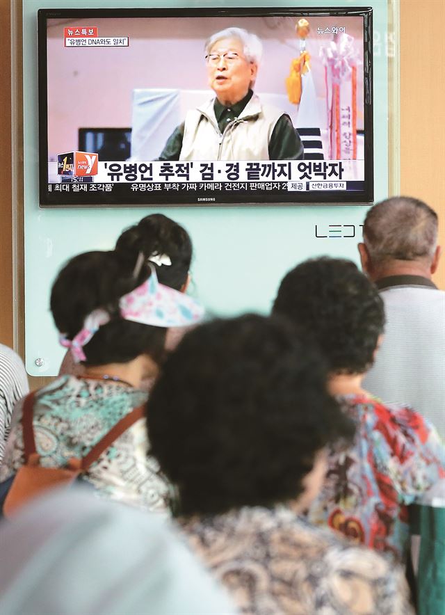 지난달 12일 전남 순천시 서면 학구리 매실밭에서 발견된 변사체의 DNA가 '세월호 실소유주' 유병언 전 세모그룹 회장과 일치한다고 경찰이 발표한 가운데 22일 오후 서울역에서 시민이 관련 뉴스를 보고 있다. 연합뉴스/2014-07-25(주간한국)/2014-07-25(주간한국)