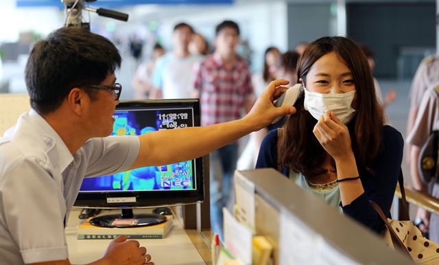 지난 8일 인천국제공항 입국장에서 검역소 관계자가 입국하는 여행객의 체온을 검사하고 있다. 연합뉴스