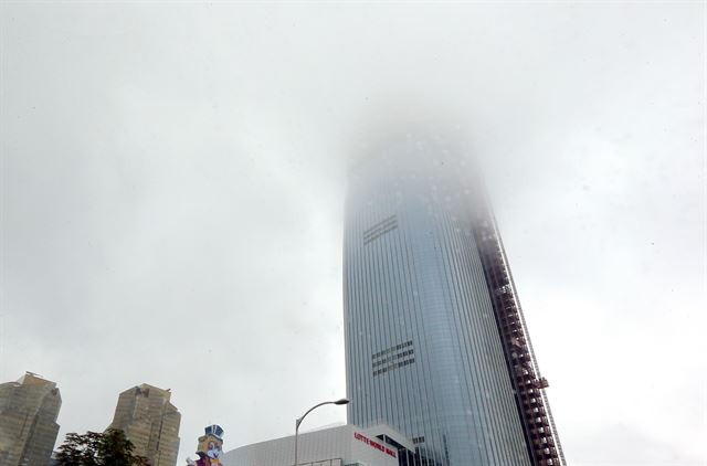 19일 오후 서울 잠실에서 건축중인 제2롯데월드 타워가 가을장마를 몰고 온 먹구름 속에 갇혀 있다. 연합뉴스