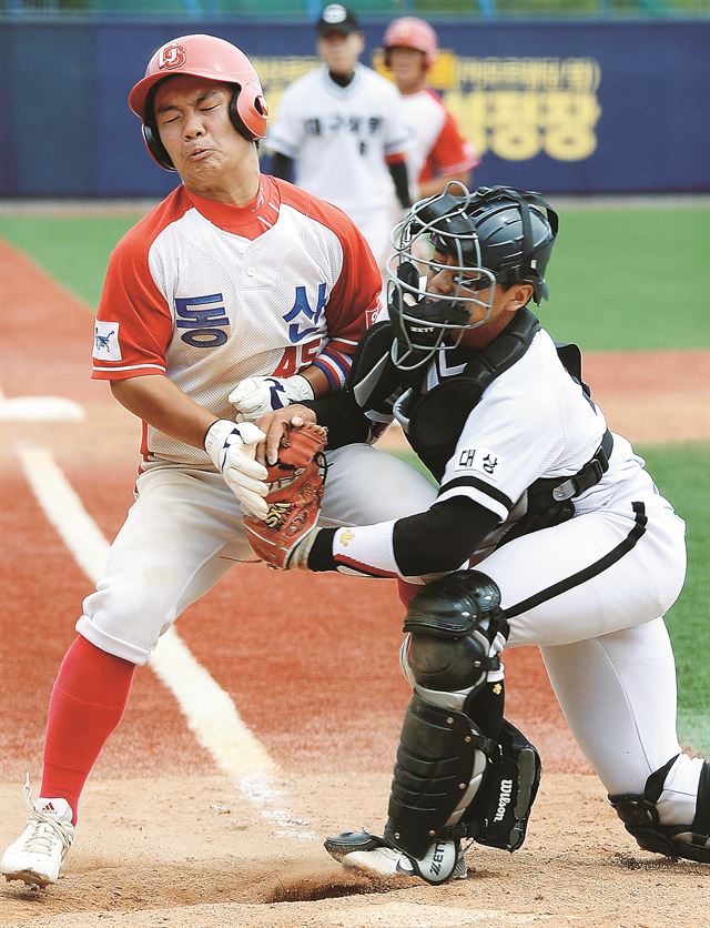 동산고 김성수(왼쪽)가 31일 포항구장에서 열린 봉황대기 전국고교야구대회 상원고와의 1회전 5회 무사 2ㆍ3루 득점 찬스에서 정순찬의 내야 땅볼 때 홈으로 들어오다 태그 아웃 당하고 있다. 포항=왕태석기자 kingwang@hk.co.kr