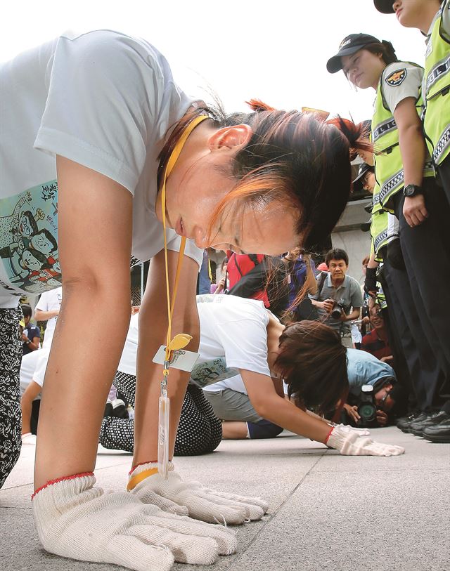 세월호 참사 희생자 유가족들이 2일 오후 서울 광화문광장에서 세월호특별법 제정을 촉구하며 삼보일배를 하고 있다. 이들은 앞서 국회에 전달한 350만명의 특별법 제정 촉구 서명에 이어 추가로 130만명으로부터 받은 서명지를 광화문광장에서부터 청와대까지 삼보일배를 하며 전달할 예정이었지만, 세종대왕 동상 앞에서 경찰병력에 가로막혔다. 연합뉴스