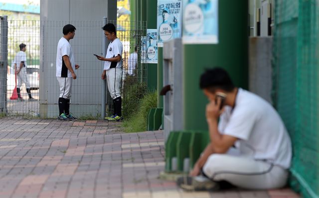 11일 경기도 고양시 국가대표 야구훈련장에서 열린 고양 원더스 선수단 미팅에서 팀 해체 결정이 발표되자 선수들이 지인들에게 소식을 전하고 있다. 연합뉴스