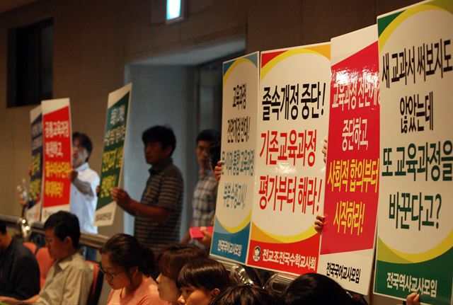 12일 오후 청주시 한국교원대학교 교원문화관에서 '문·이과 통합형 교육과정 총론 주요사항 공청회'에서 전국교직원노동조합 소속 노조원들이 통합형 교육과정을 반대하는 팻말을 들고 있다. 연합뉴스