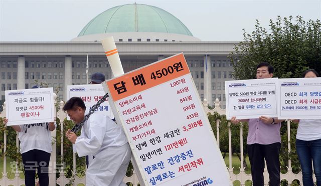 국내 최대 흡연자 커뮤니티 아이러브스모킹 회원들이 15일 오전 서울 여의도 국회의사당 앞에서 담뱃값 인상에 반대하며 무거운 담배를 어깨에 짊어지고 가는 퍼포먼스를 하고 있다. 배우한기자bwh3140@hk.co.kr