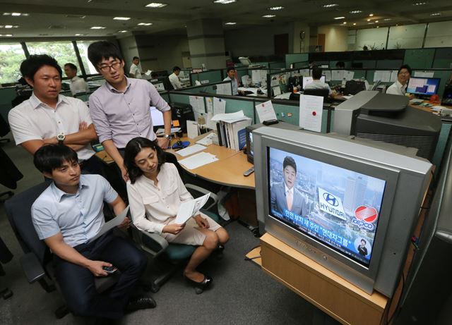 현대차그룹이 서울 삼성동 한전부지 인수에 성공한 18일 오전 서울 서초구 양재동 현대차그룹 사옥에서 직원들이 관련 뉴스를 지켜보고 있다. 현대차그룹은 공식 입장을 내고 "한전부지에 그룹의 제2 도약을 상징하는, 차원이 다른 공간으로 글로벌비즈니스센터를 건립하겠다"고 밝혔다. 연합뉴스