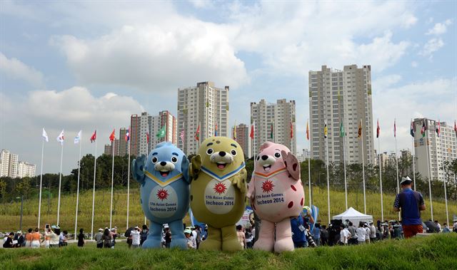 26일 오전 인천광역시 남동구 구월아이아드선수촌 사전 홍보를 위한 보도진 공개행사가 열린 선수촌 국기광장에 아시아경기대회 마스코트인 물범 삼형제가 북한 인공기를 비롯한 대회 참가국들의 국기가 펄럭이는 가운데 포토타임을 하고 있다. 뉴시스