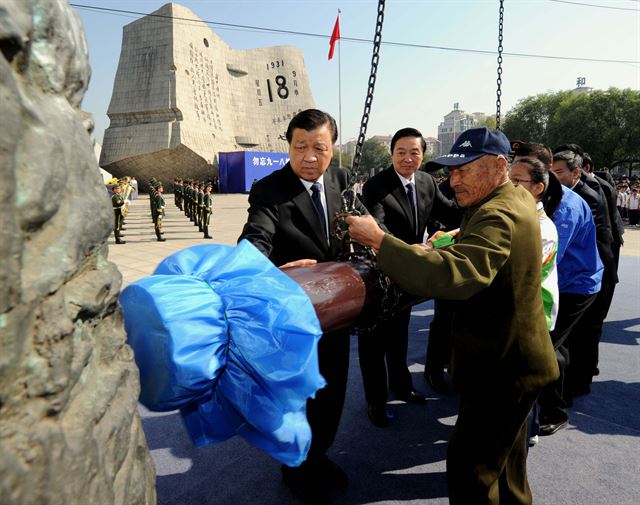 만주사변 83주년을 맞은 18일(현지시간) 만주사변의 현장인 랴오닝성 선양에서 열린 기념행사에 참석한 류윈산 중국 공산당 중앙정치국 상무위원이 시민들과 함께 14년 간의 항일전쟁을 의미하는 '경세의 종'을 타종하고 있다. 선양=신화 연합뉴스