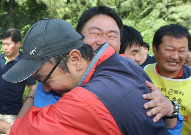 18일 오후 현대자동차 하청업체 소속 비정규직 노동자를 현대차의 정규직 근로자로 인정한 법원의 판결이 나온 뒤 서울 서초구 서초동 서울 중앙지법에서 모인 현대차 비정규직 노동자들이 서로 얼싸안고 기뻐하고 있다. 연합뉴스