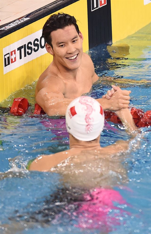 박태환이 21일 인천 문학박태환수영장에서 열린 아시안게임 남자 자유형 200m 결승에서 3위로 레이스를 마친 뒤 2위를 차지한 쑨양(중국)과 악수를 하며 웃고 있다. 인천=연합뉴스