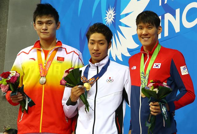 21일 인천 문학박태환수영장에서 열린 2014 인천 아시안게임 수영 남자 200m 시상식에서 메달리스트들이 취재진을 향해 포즈를 취하고 있다. 오른쪽부터 동메달을 차지한 한국의 박태환, 금메달을 차지한 일본의 하기노 고스케, 은메달을 차지한 중국의 쑨양. 연합뉴스