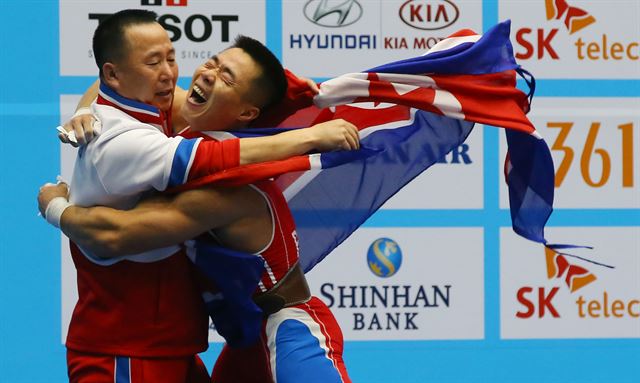 지난 20일 인천 달빛축제정원역도경기장에서 열린 '2014 인천 아시안게임' 남자 역도 62k급 A그룹 경기에서 북한 김은국이 용상 3차시기 178kg을 성공한 뒤 감독과 기뻐하고 있다. 이날 김은국은 인상 154㎏(세계신기록)·용상 178㎏·합계 332㎏(세계신기록)을 기록해 북한에게 두번째 금메달을 안겼다. 연합뉴스