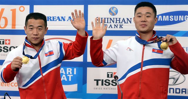 인천 아시안게임 역도 세계신기록을 세운 북한의 엄윤철(왼쪽)과 김은국이 23일 메일 프레스센터에서 열린 기자회견에서 금메달을 목에 걸고 포즈를 취하고 있다. 인천=뉴시스