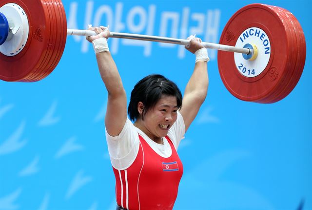 지난 22일 달빛축제정원 역도경기장에서 열린 2014 인천 아시안게임 역도 여자 58kg급 경기에서 북한의 리정화가 용상 2차 시기에서 134kg을 들어올리고 있다. 리정화는 인상 102kg, 용상 134kg 합계 236kg으로 2위 중국의 왕 솨이를 1kg 앞서며 금메달을 획득했다. 연합뉴스