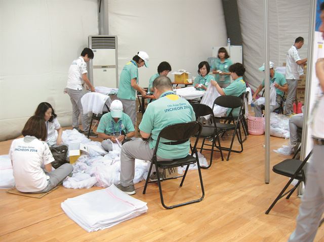 인천아시안게임 자원봉사자들이 24일 구월아시아드선수촌 공동세탁장에서 세탁망을 정리하고 있다. 자원봉사 활동 중 가장 고된 일로 꼽히는 것이 세탁물 관리지만 이들은 “고맙다는 선수들의 인사로 피로를 잊는다”고 말했다. 권병대씨 제공