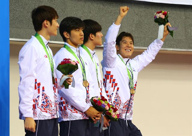 26일 인천 문학박태환수영장에서 열린 2014 인천 아시안게임 수영 남자 400m 혼계영에서 3위로 동메달을 목에 건 박태환이 시상식 도중 경기장에 온 전 역도선수 장미란을 향해 인사하고 있다.연합뉴스