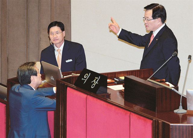 30일 국회 본회의장에 입장한 정의화 의장이 새정치민주연합의 요청으로 개회 선언을 미루자 김무성 새누리당 대표가 의장석 앞까지 내려와 항의를 하고 있다. 오대근기자 inliner@hk.co.kr