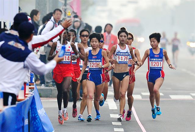 2일 2014 인천아시안게임 여자 마라톤에 출전한 한국 최보라(1176번)선수가 북한의 김혜성(1201) 김혜경(1200)선수와 함께 선두그룹으로 인천 송도컨벤시아 인근 도로를 달리고 있다. 북한 김혜성, 김혜경 선수는 쌍둥이 자매 선수로 2013년 싱가포르여자달리기경기대회 하프마라톤경기에서 동생 김혜경 선수가 1위, 김혜성 선수가 2위로 북한의 마라톤 유망주로 활약하고 있다. 인천=심현철기자 shim@koreatimes.co.kr