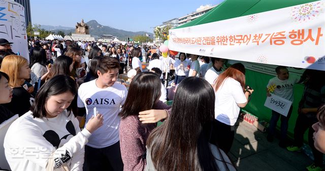 한글날을 맞은 9일 서울 광화문광장에서 주한 미국인유학생협의회가 연 ‘미국 대학의 한국어 도서관 건립을 위한 한국어 책 기증 행사’에 참여하려는 시민들이 길게 줄지어 서 있다. 김주성기자 poem@hk.co.kr