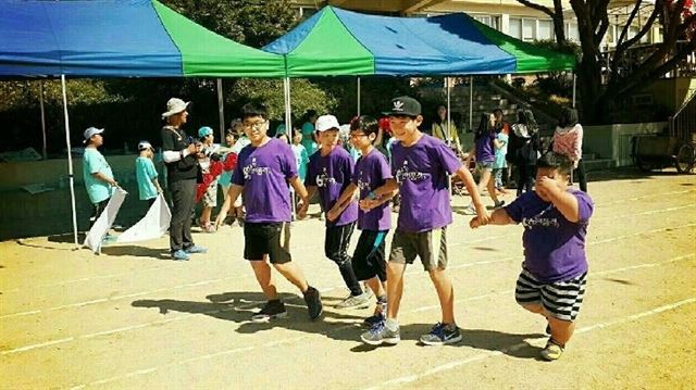 지난 22일 용인시 제일초등학교에서 열린 가을운동회 달리기 경주에서 6학년 2반 심윤섭, 양세찬, 오승찬, 이재홍 군이 연골무형성증을 앓는 친구 김기국 군을 손을 잡고 달리는 사진.