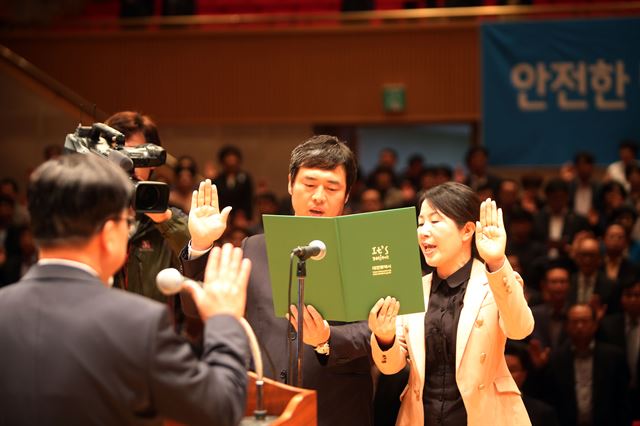 대전시 공무원 300명이 13일 지역 기업의 경쟁력 강화를 위해 '기업 도우미'로 나섰다. 이 날 대전시청에서 열린 발대식에서 윤준호 (주)성광 대표와 공무원이 성실한 활동을 다짐하는 선서를 하고 있다. 연합뉴스